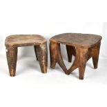Two African tribal art stools, each with carved decoration, raised on fluted column supports,