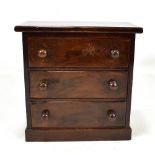 An early 20th century stained mahogany miniature three drawer chest, height 23.5cm.