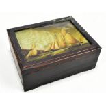 A mahogany box with glazed top with picture of boats.