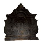A 19th century French shaped cast iron fire back with fleur-de-lys and scroll decoration, 92cm x