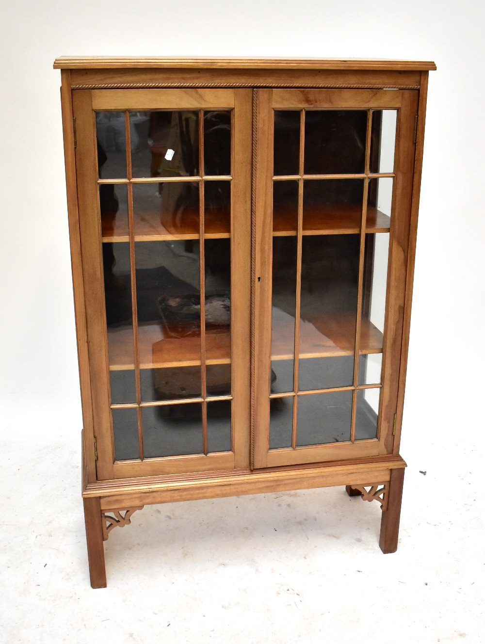 An early 20th century mahogany twin door display cabinet raised on block supports, height 140.5cm.