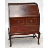 An Edwardian mahogany inlaid bureau with fall front above two short and one long drawer raised on