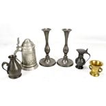 A small group of metalware comprising a pair of candlesticks, two jugs, a small brass vase and a