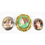 Three hand painted ceramic brooches of oval form, including a yellow metal framed example with a