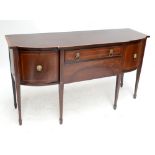 A mahogany sideboard with two central drawers flanked by two panelled cupboard doors on tapered