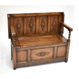 A 1920s/30s oak monk's bench, with carved and panelled decoration, length 114cm.