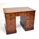 A mahogany twin pedestal desk with inset gilt tooled leather top above arrangement of nine