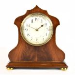 An Edwardian mahogany and inlaid mantel clock, the circular dial set with Arabic numerals, the