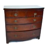 An early 19th century mahogany bowfront chest of two short and three long graduated drawers with