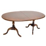 A reproduction oak D-end twin pedestal extending dining table with one extra leaf, length when not