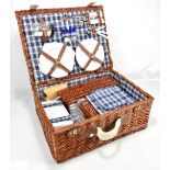 A wicker picnic basket with contents.