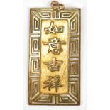 A Chinese yellow metal pendant featuring four-character phrase and engraved foliate detail to either