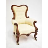 A Victorian mahogany framed armchair raised on scrolling feet.