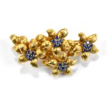 An 18ct yellow gold floral brooch, set with twenty-four sapphires, approx 19.9g.