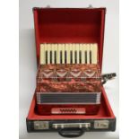 A vintage German twelve bass Galotta piano accordion, red marbled finish, in leather carry case.