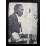 A signed black and white photograph of John Lee Hooker with 'Copyright Photograph 1964 John