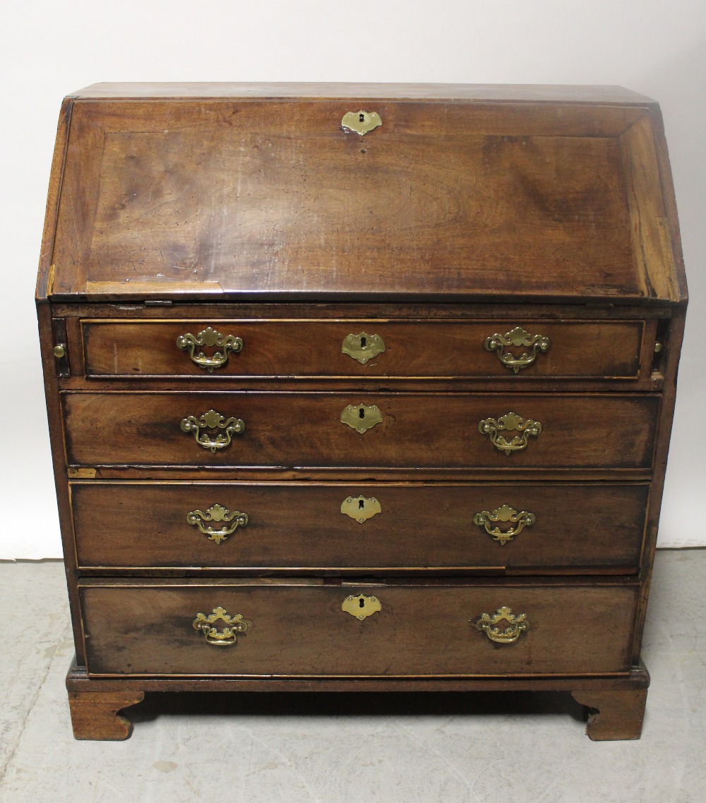 A George III mahogany bureau, the fall-front enclosing fitted interior above four drawers,