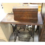 An early 20th century treadle sewing machine raised on iron base.