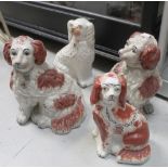 A pair of late 19th/early 20th century Staffordshire dogs with freestanding front leg,