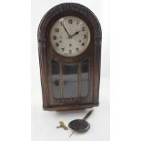 An early 20th century oak-cased dome topped wall clock, the silvered dial set with Arabic numerals,