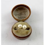 A yellow metal ladies' dress ring set with two pearls on a twist, size T.