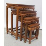 A Chinese hardwood nest of four rectangular tables with carved and pierced details of birds amongst