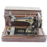 An early 20th century mahogany-cased Singer hand sewing machine, patented 1886.