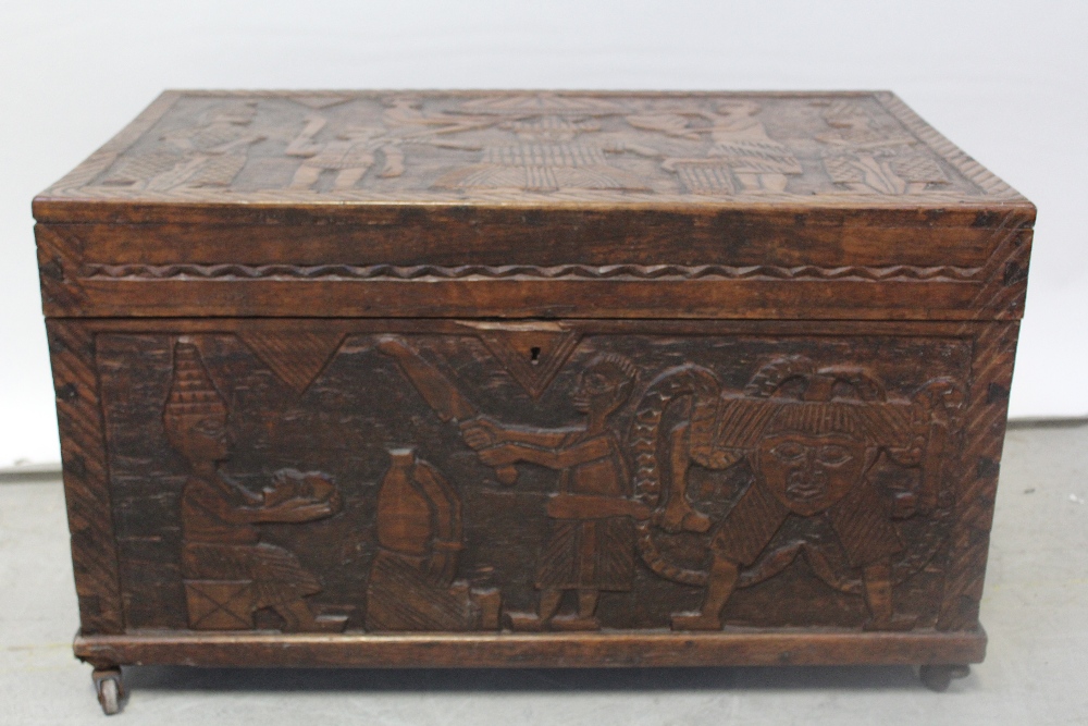 An early 20th century oak bedding box, profusely carved with South Pacific themed panels to top,