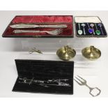 A cased set of silver and enamel teaspoons, brass travel candlesticks,