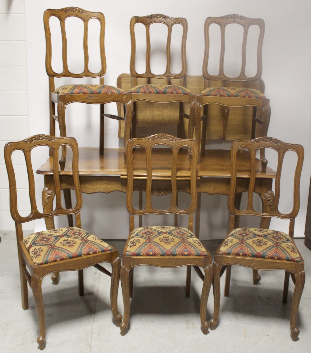 A mid-20th century oak marquetry extending dining table in the French style,