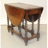 An oak dropleaf gateleg table with barleytwist supports.