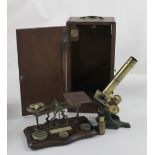 A Victorian brass microscope and lens in wooden case,