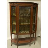 An Edwardian mahogany inlaid display cabinet central astragal glazed doors with serpentine glass to