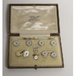 A cased set of 9ct white and yellow gold cufflinks and collar studs, each set with small sapphire,