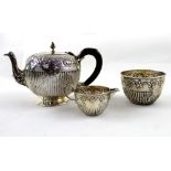 A Victorian hallmarked silver three-piece tea service with chased decoration, comprising teapot,