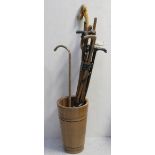 A wooden coopered stick stand with various walking canes to include a faux bamboo example,