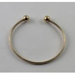 A yellow metal bangle.