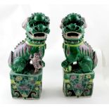 A pair of Chinese Famille Verte statues of seated lions, height 36cm.