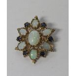 A 9ct yellow gold oval brooch set with seven opals and six sapphires,