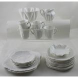 A c1920s Shelley white Art Deco part tea service to include three cake plates, eleven small plates,