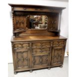 An early 20th century oak mirror-back sideboard, raised panels to either side of octagonal mirror,