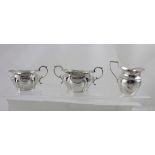 An Edward VII hallmarked silver cream jug and matching sugar bowl, each of oval form,