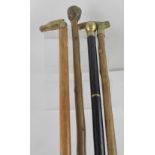 Four reproduction walking sticks, each with brass finials (4).