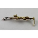 An Edwardian yellow metal bar brooch in the form of a riding crop with fox mount, approx 6.8g.