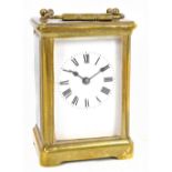 A circa 1900 French brass carriage clock, the white enamel dial set with Roman numerals and the door