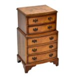 A reproduction burr walnut veneered chest of two short over three long drawers of small proportions,