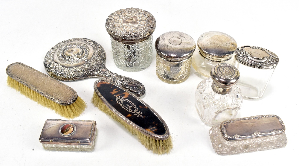 A quantity of silver dressing table items including glass trinket jars and covers, brushes, hand