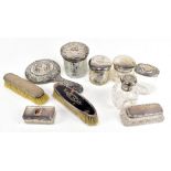 A quantity of silver dressing table items including glass trinket jars and covers, brushes, hand