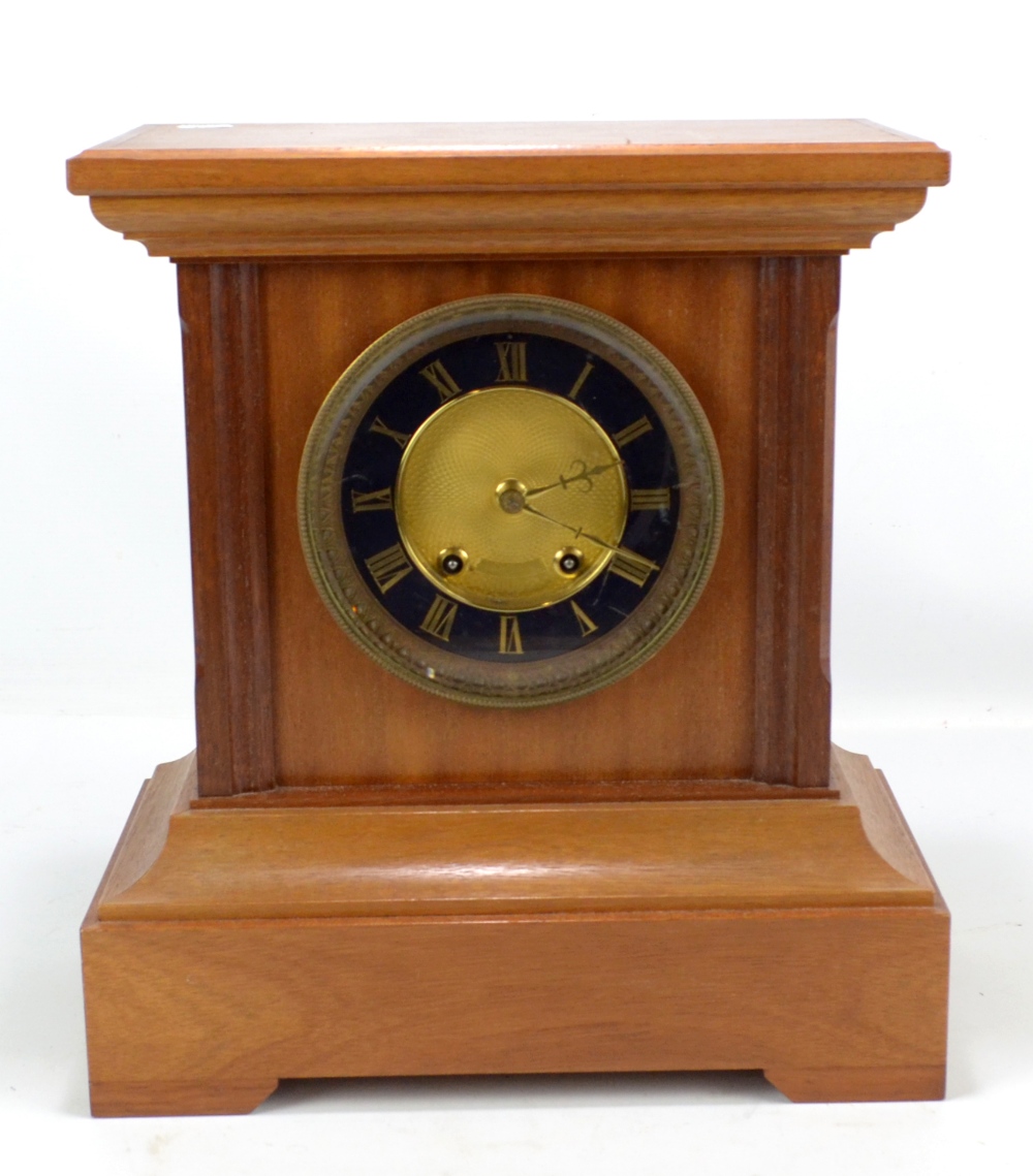 A late 19th/early 20th century mantel clock, the circular dial set with gilt Roman numerals, the