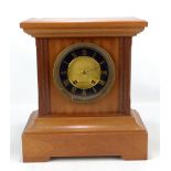 A late 19th/early 20th century mantel clock, the circular dial set with gilt Roman numerals, the